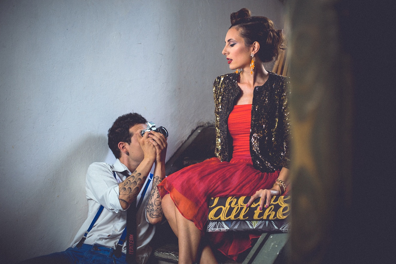 On fotografiše nju na stepenicama — dramatično osvetljenje i šljokičasta jakna