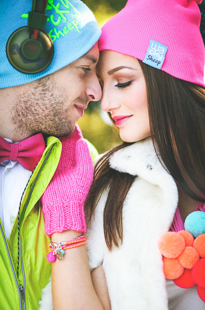 Mlada u beloj haljini od tila sa roze hulahopkama, roze kapicom i šarenom ogrlicom na snegu