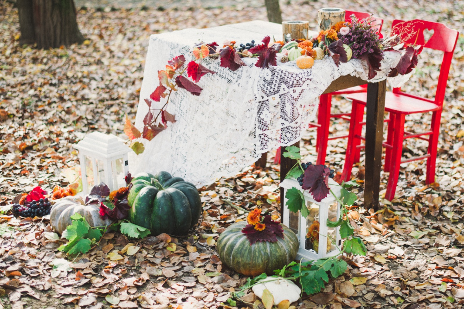 Hrizanteme i sveće među jesenjim plodovima