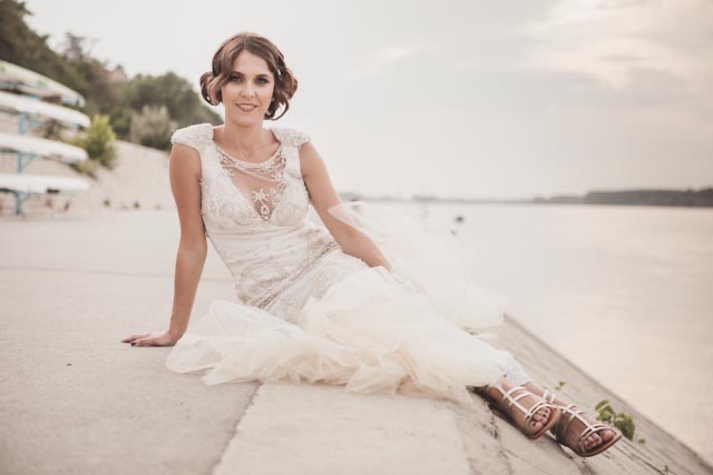 Dušica na keju — venčanica, ravne sandale, reka u pozadini