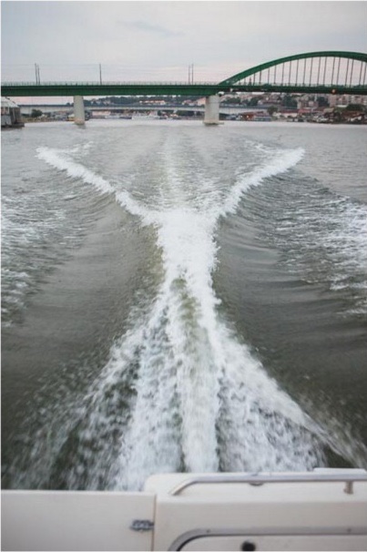 Trag broda na reci — most u pozadini, brodski trag u peni