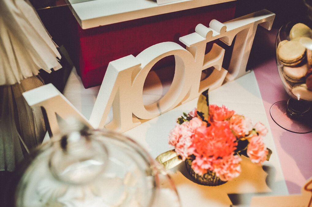 Postavljeni sto za romantičnu večeru — roze stolnjak, zlatne sveće, ruže i šampanjac