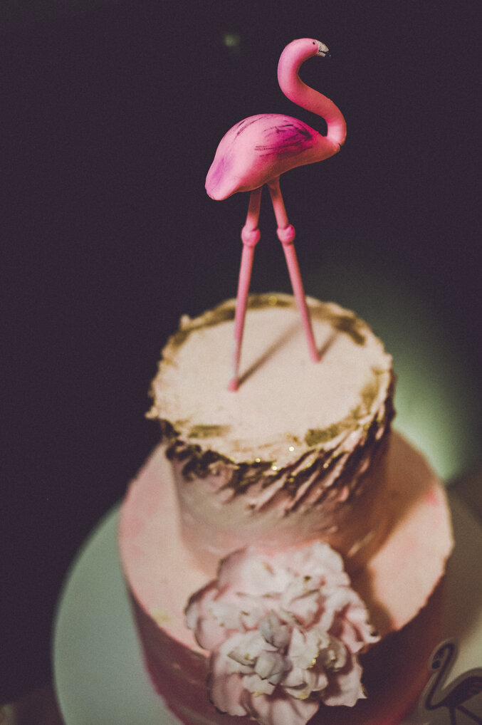Roze flamingo dekoracija na stolu sa svećama i makaronima