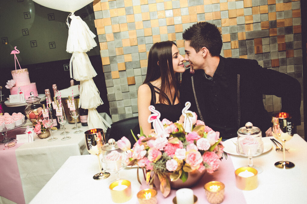 Sto sa roze cvećem i šampanjcem noću