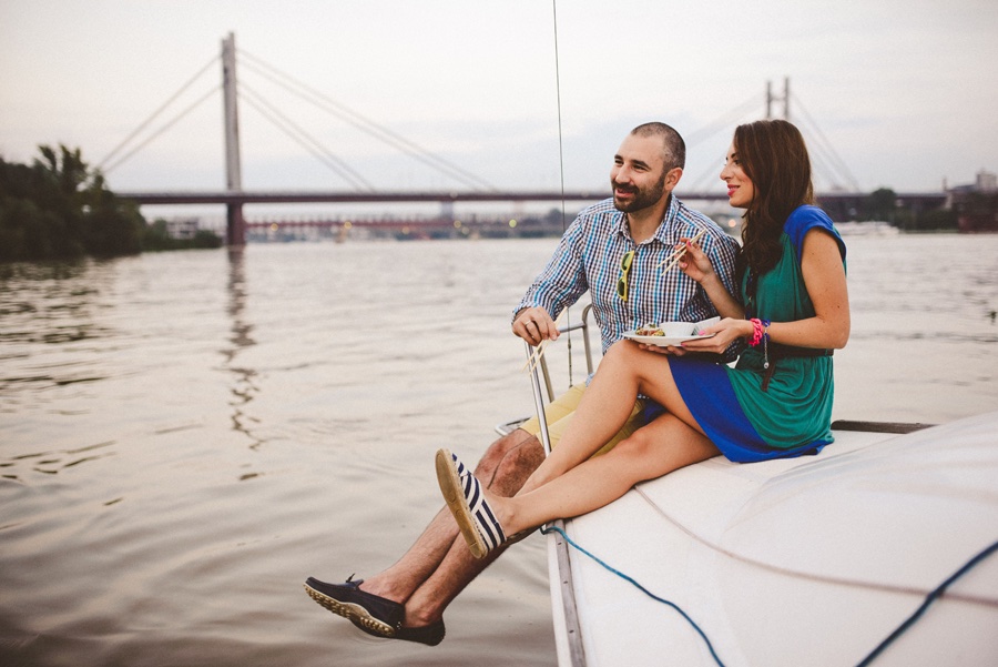 Dušica i Goran na jedrilici — reka i most u pozadini