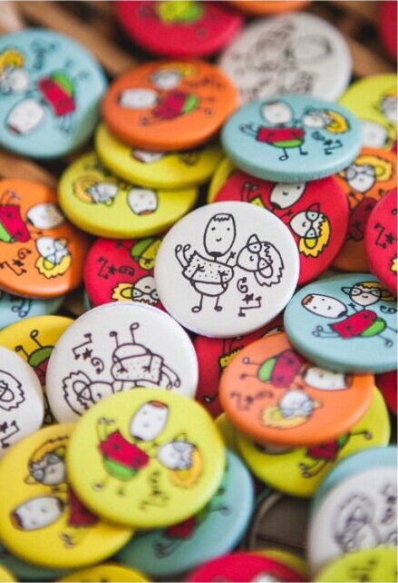 Gomila šarenih bedževa za goste