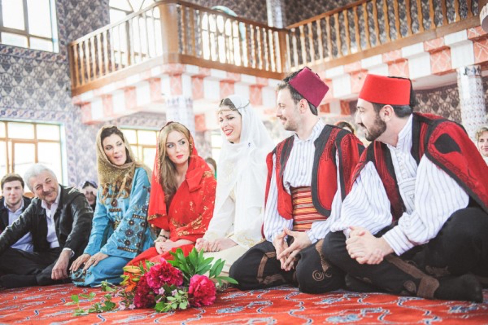 Unutrašnjost džamije Sultan Murat II — orijentalna keramika, drveni rezbareni detalji, svi sede na tepihu