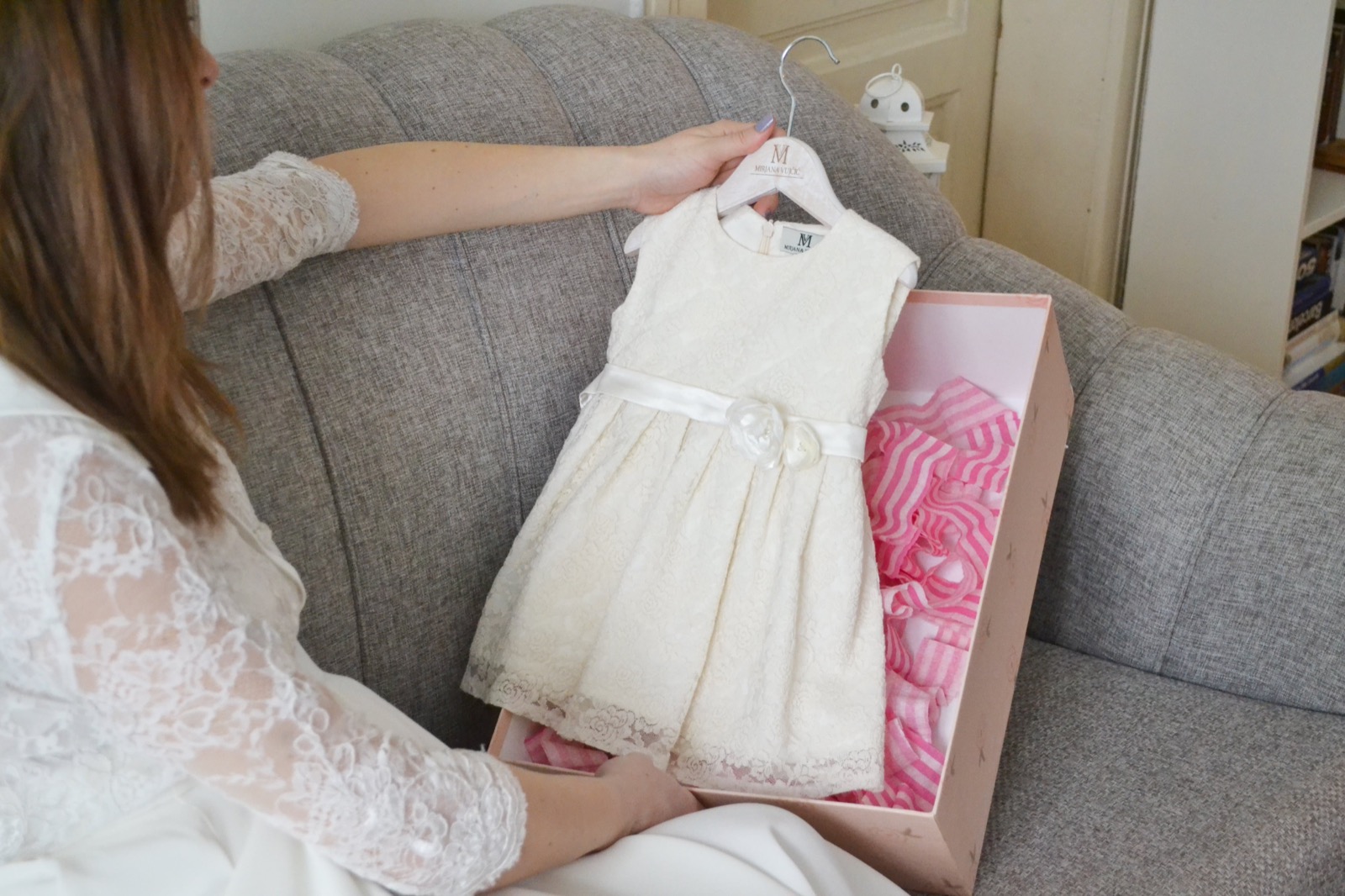 Mirjana Vujčić dečja haljina — bela čipka sa satenskom trakom u roze kutiji