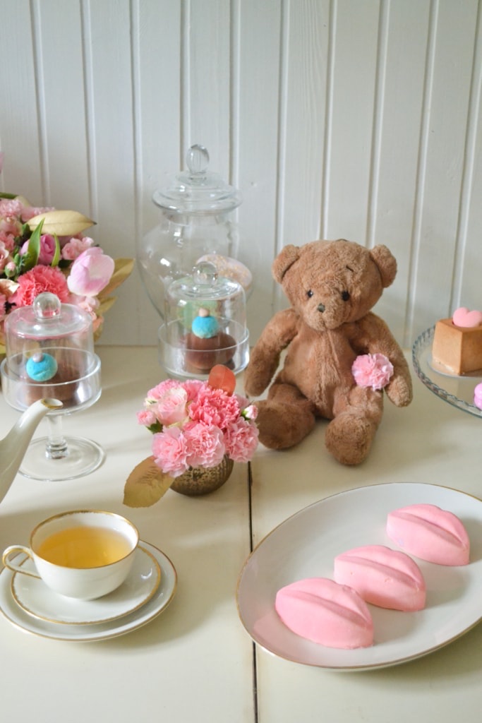 Ružičasti kolači, meda, cveće i čaj — pastelni mrtva priroda
