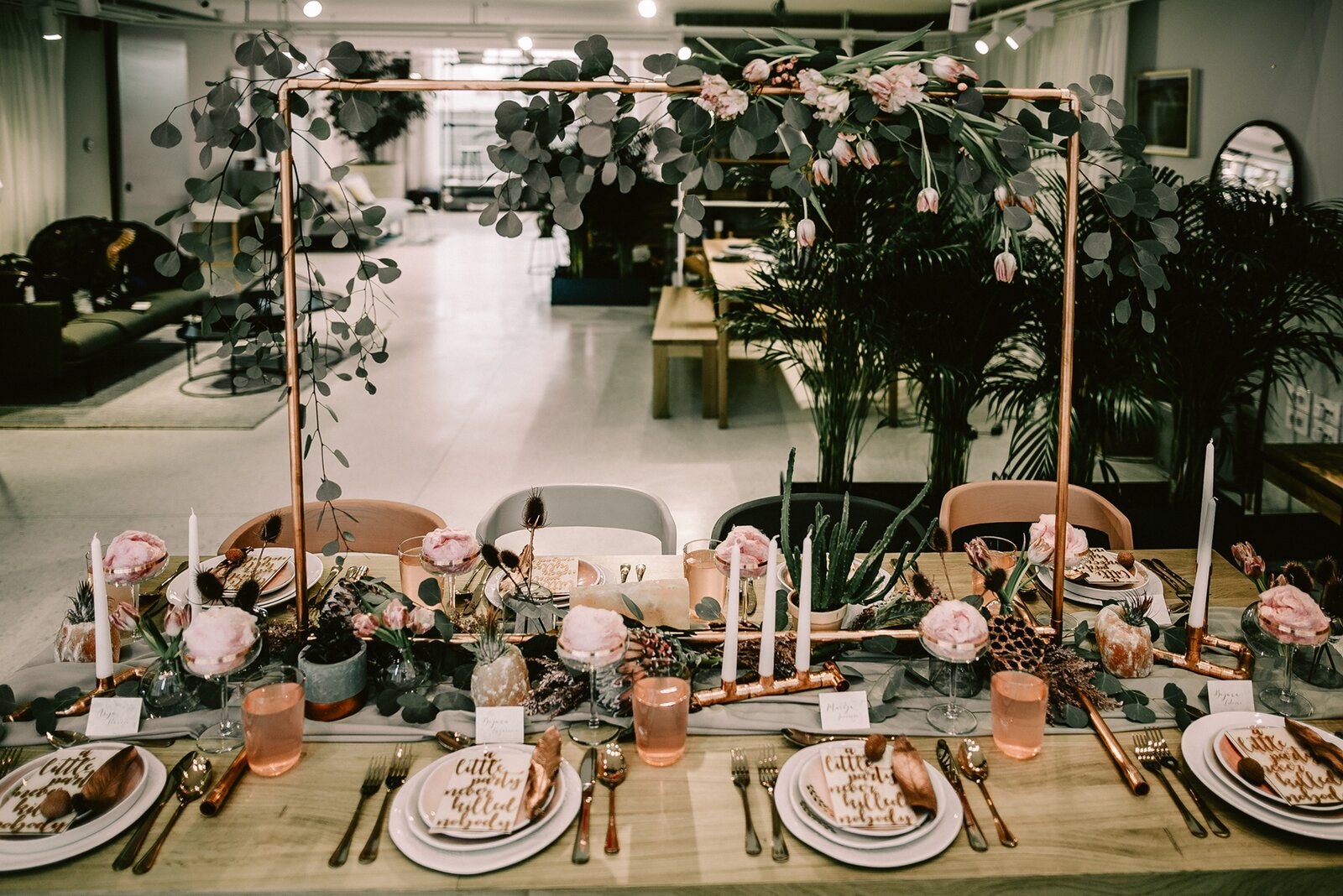 Sto dekorisan bakarnim cevima, eukaliptusom i blush ružama