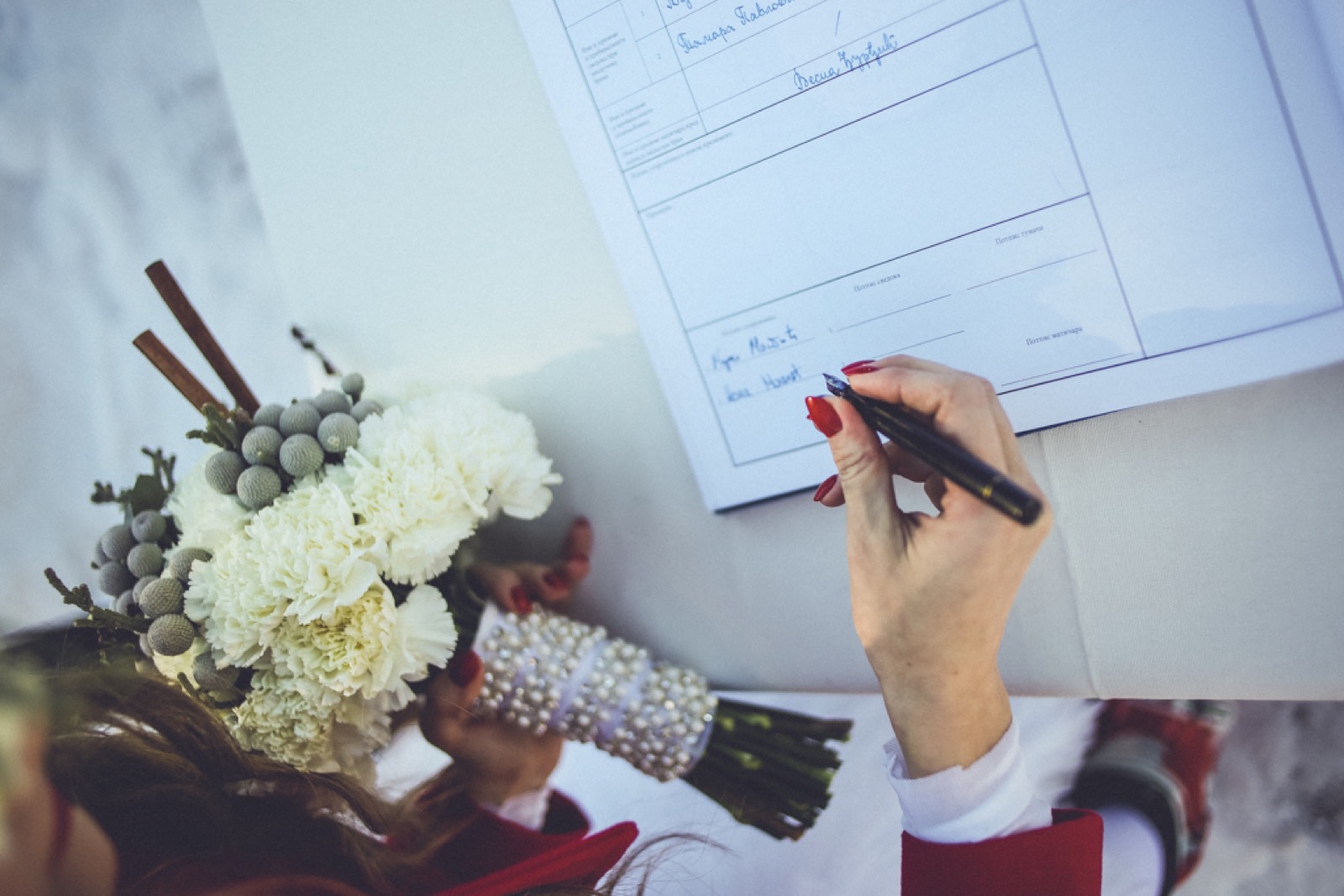 Mlada potpisuje venčani dokument sa crvenim noktima