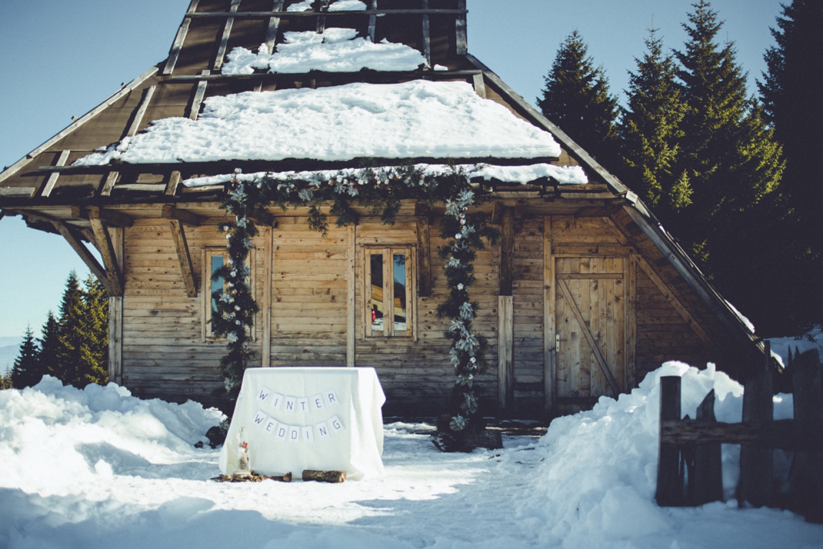 Par pod venčanim lukom od zelenja u snežnom pejzažu