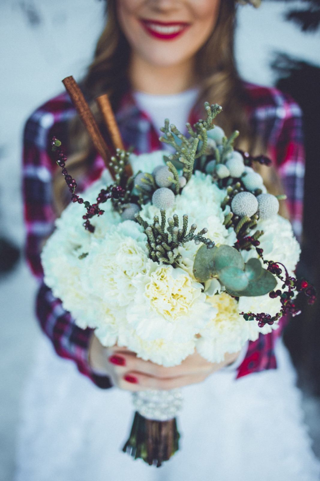 Mlada i mladoženja se ljube pod venčanim lukom