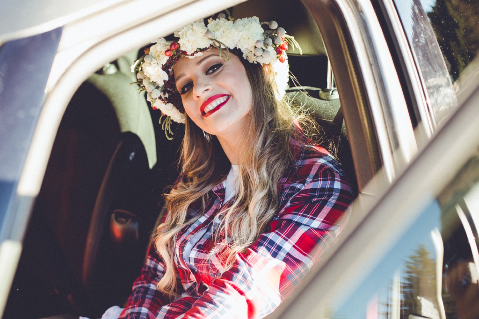 Mlada Nena se smeje u automobilu sa cvetnim vencem