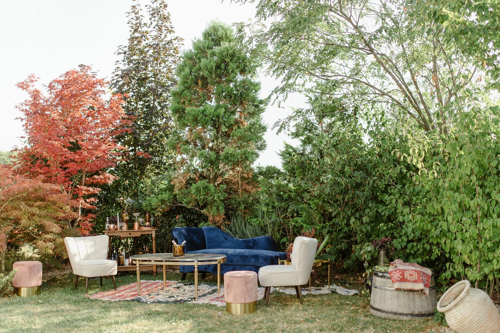 Lounge zona — plavi baršunski kauč, krem fotelje u bašti