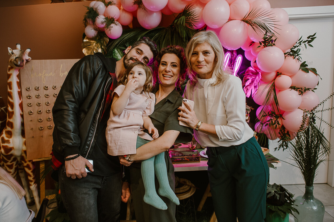 Porodica ispred balona i neonskog natpisa