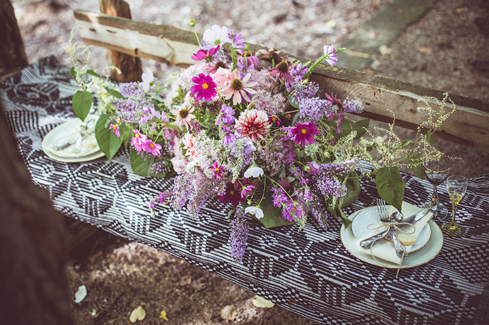Model u dugoj bordo haljini sa zlatnim nakitom — hoda šumskom stazom